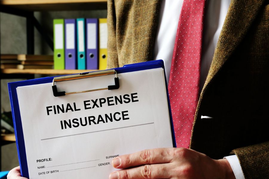 An agent in Portage, MI holding a final expense insurance form
